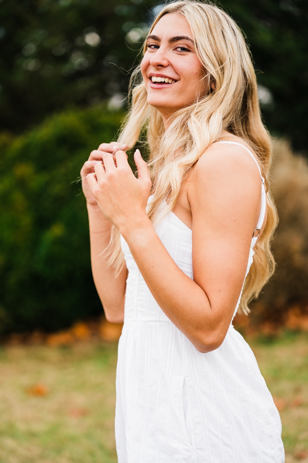 Cecilia Pogue: smiling outdoor portrait in a white dress